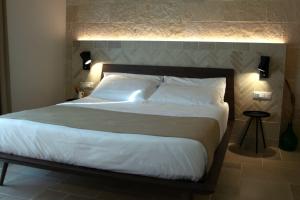 a bedroom with a large bed with lights on it at Dimora al Piano in Matera