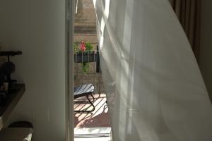 a view of a balcony with a white curtain at Dimora al Piano in Matera