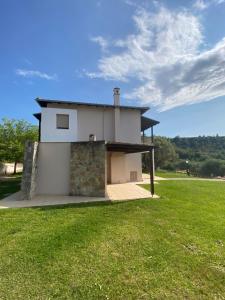 a house with a grassy field in front of it at Pefkohori Suits in Pefkochori +4 photos