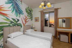 伏罗拉Le Palazzine Hotel的壁画客房内的两张床