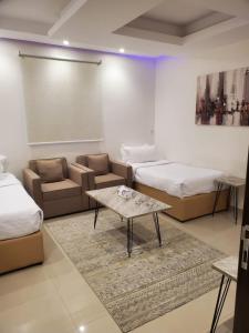 een kamer met 2 bedden en een tafel en een bank bij شقق مسكن ايار - Ayar Residence in Riyad +79 foto's