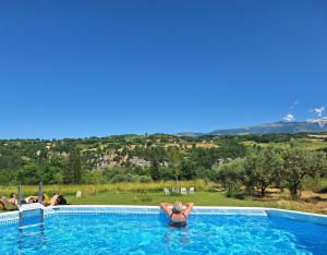 a woman in a swimming pool with a view at Villa Vista Monti in Bolognano