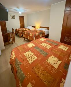 a hotel room with two beds and a television at Hotel La Molina in Lima