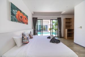 a bedroom with a large white bed with pillows at Bang tao modern holiday style pool view high speed WiFi in Laguna Phuket +273 photos