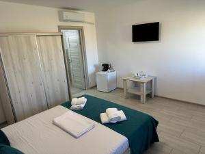 a bedroom with a bed with towels on it at Houses by the sea in Vadu
