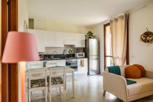 a kitchen with white cabinets and a table and a couch at Appartamento Dolce Casa 2 in  Monvalle 