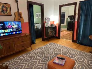 a living room with a flat screen tv on a dresser at Friendly Songbird Suite in Berwyn +11 photos