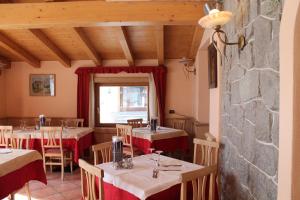 un restaurant avec des tables et des chaises et un mur en pierre dans l'établissement Hotel Miramonti, à Livigno