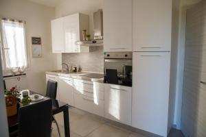 a white kitchen with white cabinets and a table and a tableablish at Oasi Sant'Egidio in Fano