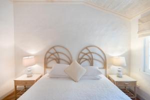 Un dormitorio con una cama blanca con dos mesitas de noche. en Waverly House townhouse, en Saint Peter