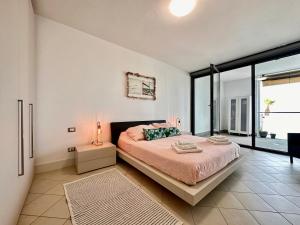 a bedroom with a bed and a large window at Marina dei Sogni Bilocale - Fronte mare con parcheggio gratuito e aria condizionata in San Lorenzo al Mare
