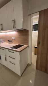 a kitchen with white cabinets and a counter top at Studio moderne et spacieux 2 in Draveil