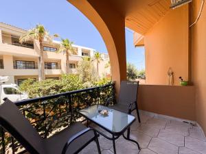 a patio with two chairs and a table on a balcony at Villa Eleni Seaside Apartments in Plataniás