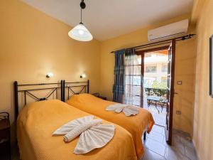 a bedroom with two beds with bows at Villa Eleni Seaside Apartments in Plataniás