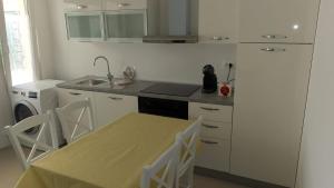 a kitchen with a table and a sink and a stove at Seaview apartment Lukić in Supetar