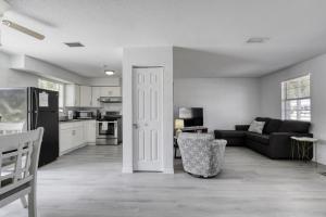 a living room with a black couch and a kitchen at Coquina Cabana with fenced yard and adorable decor in South Daytona