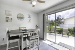a dining room with a table and chairs and a sliding glass door at Coquina Cabana with fenced yard and adorable decor in South Daytona +36 photos