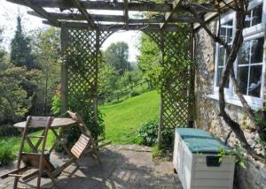 eine Pergola mit einem Picknicktisch und einer Bank in der Unterkunft Yarde cottage rural Devon Dog friendly in Membury