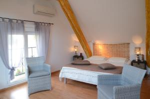 a bedroom with a large bed and two chairs at Chambre d'hôtes au Domaine de la Moretie in Cublac +19 photos