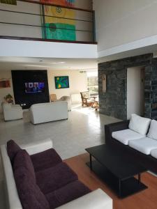 Una sala de estar con dos sofás blancos y una chimenea. en Aguas Claras Hosteria, en Santa Rosa de Calamuchita