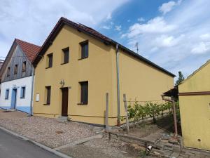 a yellow house on the side of a street at Penzion Púrynky in Velké Bílovice