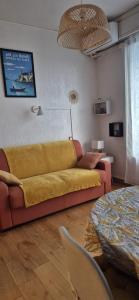 a living room with a yellow couch and a table at Studio 181 Albion Residence Beautiful view and pool! in Aix-les-Bains