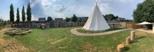 a yard with a white tent in the grass at Le tipi d'Adri in Gesves +8 photos