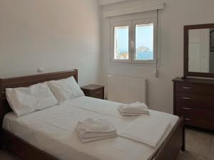 a bedroom with a bed with two towels on it at Seaview Complex with Pool in Porto Rafti +24 photos