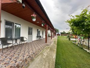a porch of a house with chairs and a patio at Houses by the sea in Vadu +48 photos