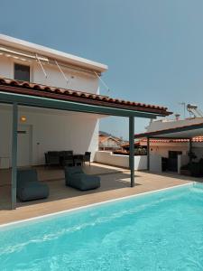 a house with a swimming pool and a patio at Seaview Complex with Pool in Porto Rafti