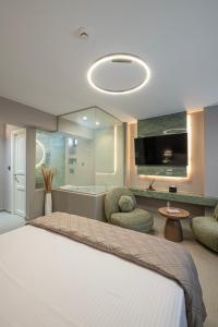 a bedroom with a bed and a tub and a tv at Acropoleos Suites in Thessaloniki