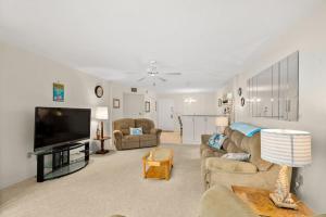 オーモンド・ビーチにあるCozy Ocean Condo with Pool & Moreのソファと薄型テレビのあるリビングルーム