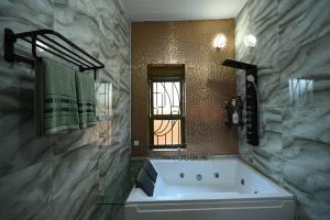 baño con bañera grande y ventana en Cascade Cove Kampala -Jacuzzi - Gazebo with Fountain, en Kampala 37 fotos más