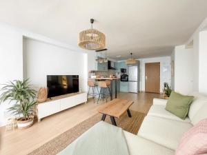 a living room with a white couch and a tv at Ocean views from every corner in Almería