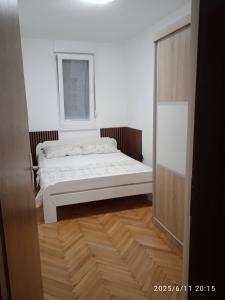 a white room with a bed and a window at Stan na dan in Ljubuški