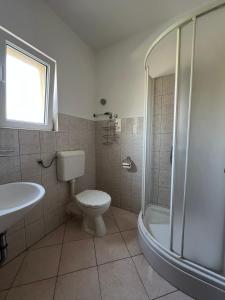 a bathroom with a toilet and a shower and a sink at Sunce economy room with kitchenette in Grebaštica