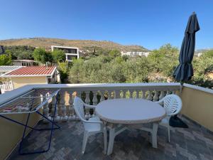 a balcony with a table and chairs and an umbrella at Economy room with kitchenette in Grebaštica