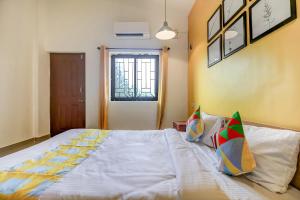 a bedroom with a large bed with white sheets at Hotel O Spacious Holiday Home in Goa