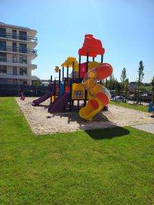 a playground with a slide in a park at Apartament rodzinny 47, 150 m od plaży, basen, plac zabaw, darmowy parking! in Sianozety