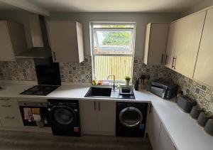 una cucina con lavello e lavatrice di Peeams Abode Erith a Erith