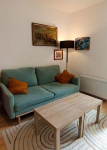 een woonkamer met een groene bank en een salontafel bij Cozy independent studio in Roussillon en Isere