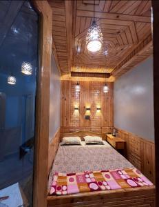 a bedroom with a bed in a room with wooden walls at The Wooden Homestay in Almora
