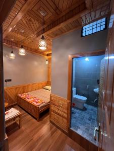 a bathroom with a bed and a shower and a toilet at The Wooden Homestay in Almora