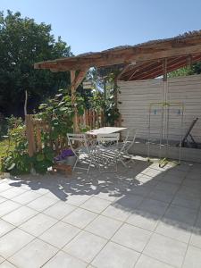 een patio met een tafel en stoelen onder een paviljoen bij Cozy independent studio in Roussillon en Isere