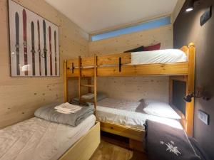 two bunk beds in a room with skis on the wall at Stella Alpina San Martino di Castrozza vista Pale in San Martino di Castrozza