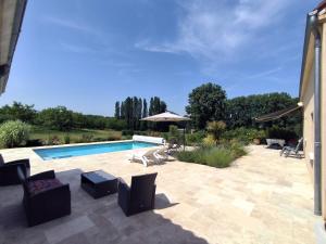 a patio with a swimming pool and a house at Villa Poujol en Dordogne, piscine chauffée in Saint-Crépin-et-Carlucet