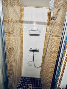 a bathroom with a shower with a black and gold tiles at Studio proche Tram T2 in Courbevoie +10 photos