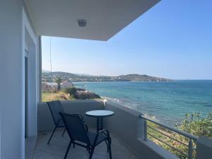 a balcony with chairs and a table and the ocean at Maria's Beach House in Karfas