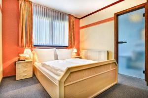 a bedroom with a large bed and a window at Hôtel du Lac in Butgenbach