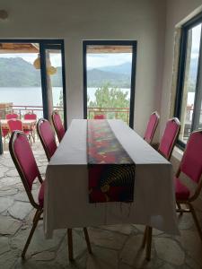 a table with pink chairs in a room with windows at cyuza paradise island in Nyarugina